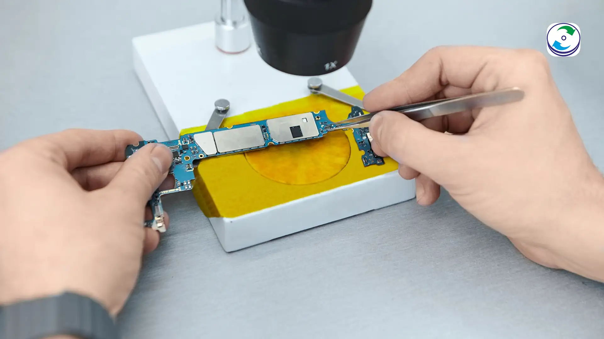 Micro-soldering technician removing a BGA NAND chip from an NVMe SSD board.